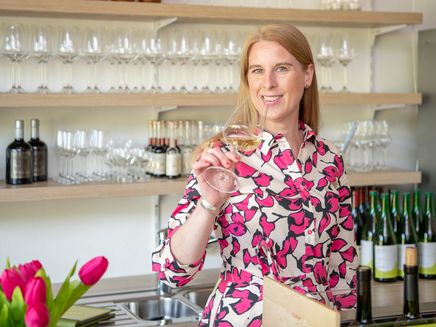 Janine Reichert The picture shows Janine Reichert with a glass of wine in her hand.