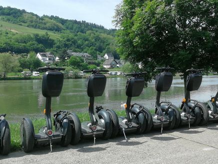 Segway Auf dem Bild steht eine Reihe von Segways. Im Hintergrund befindet sich die Mosel und der Ortsteil Kaimt.