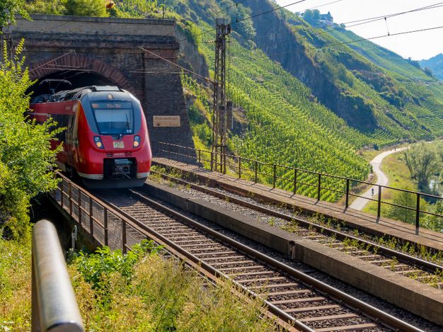 Auf dem Bild sieht man einen roten Zug der aus dem Prinzenkopftunnel fährt. 