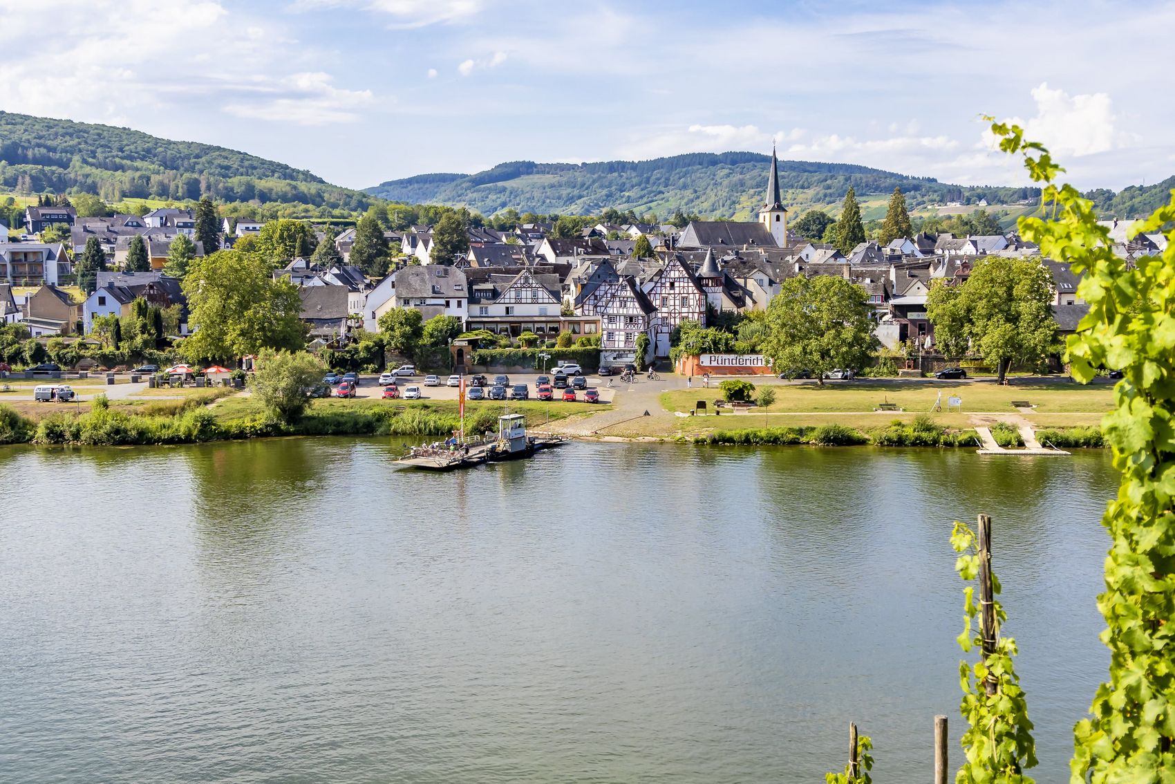 Pünderich Das Bild zeigt eine Frontalansicht von dem Moselort Pünderich mit seinen Fachwerkhäsuern. Das Bild wurde in den Weinbergen der gegenüberliegenden Moselseite aufgenommen.