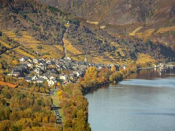 The picture shows the front view of the small Mosel village of St. Aldegund. Around it are vineyards and the Mosel.