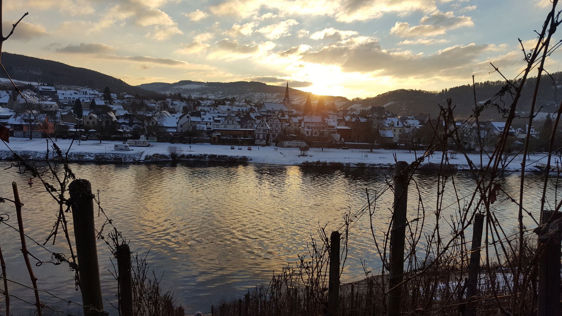 Pünderich Das Bild zeigt den Moselort Pünderich bei Schnee. Die Aufnahme wurde von der anderen Moselseite aus den Weinbergen aufgenommen.