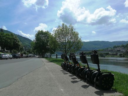 Segway fahren Auf dem Bild stehen einige Segways nebeinander an dem Moselufer auf dem Festplatz in Zell an der Mosel.